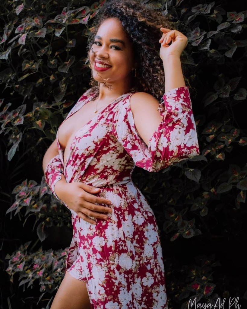 Marianela Rosabal en retrato profesional con vestido floral magenta