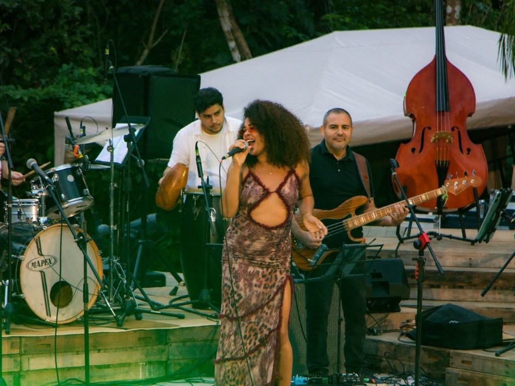 Marianela Rosabal cantando en vivo con su banda al aire libre